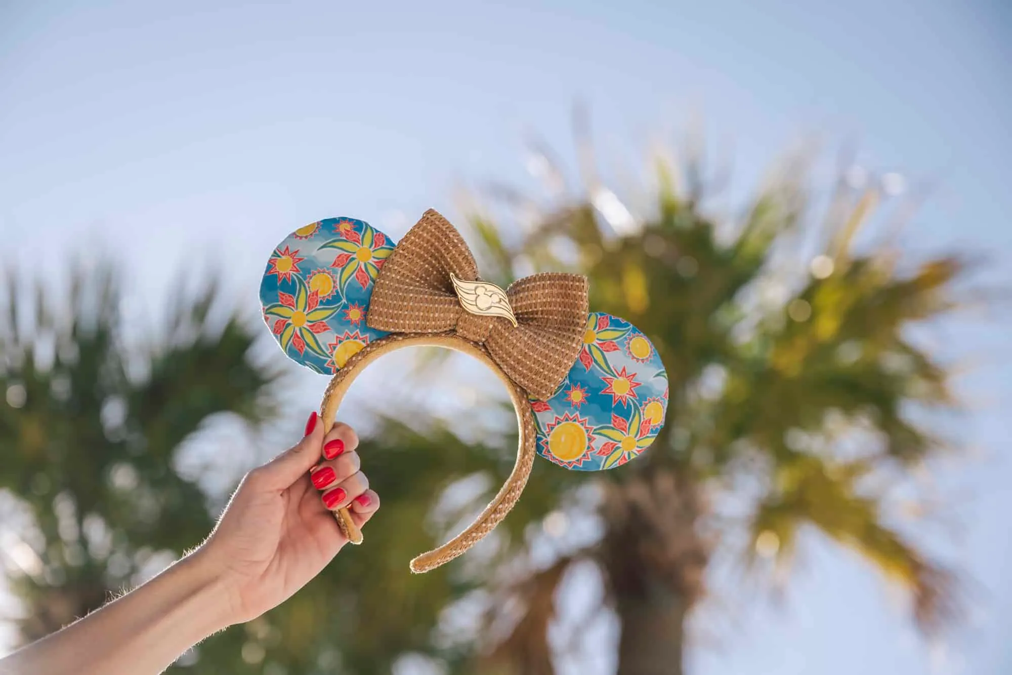 a hand holding a headband with a bow