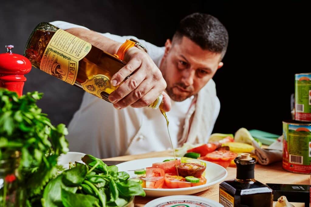 a man pouring a liquid into a plate of food